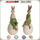 7.1" poly resin wearing green clothes Easter rabbit boy and girl statue sitting on egg