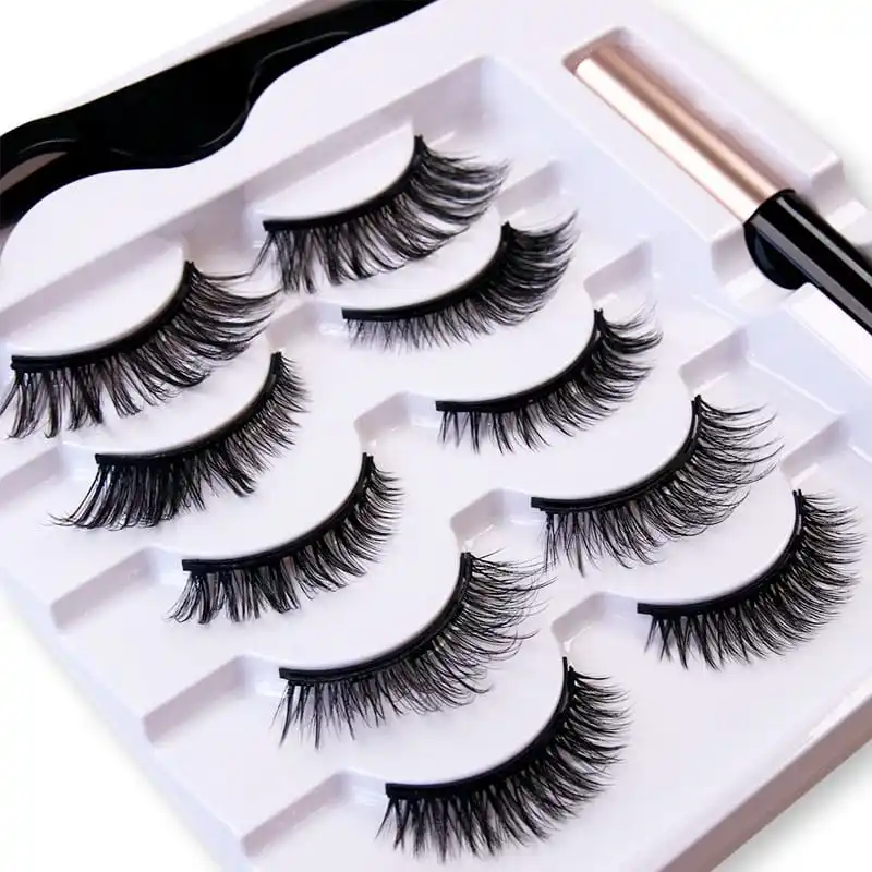 Close up of the white magnetic lash kit tray showing five pairs of lashes in moulded pockets with the curved applicator above and the liner tube in its own channel - vacuum tray lash kit engineering