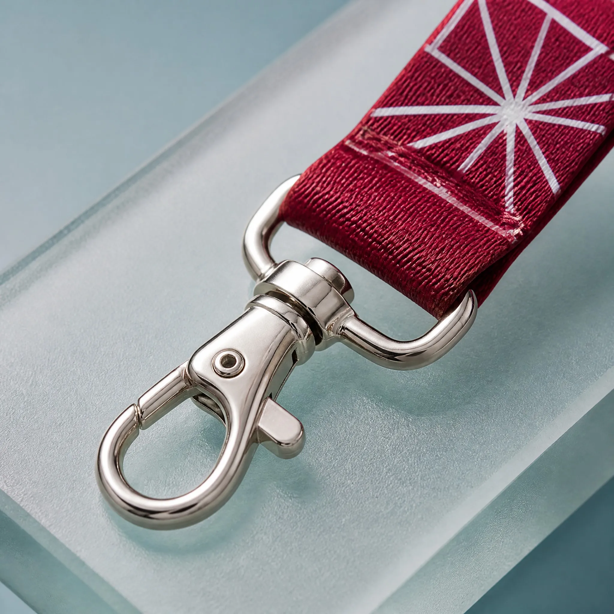 Close-up of printed polyester webbing texture and polished metal lobster claw clip