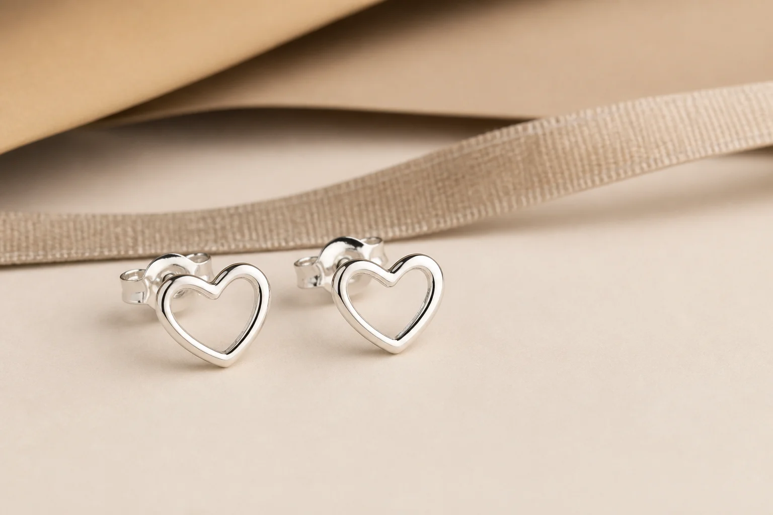 Giftable heart-shaped silver earrings presented as a seasonal jewelry option