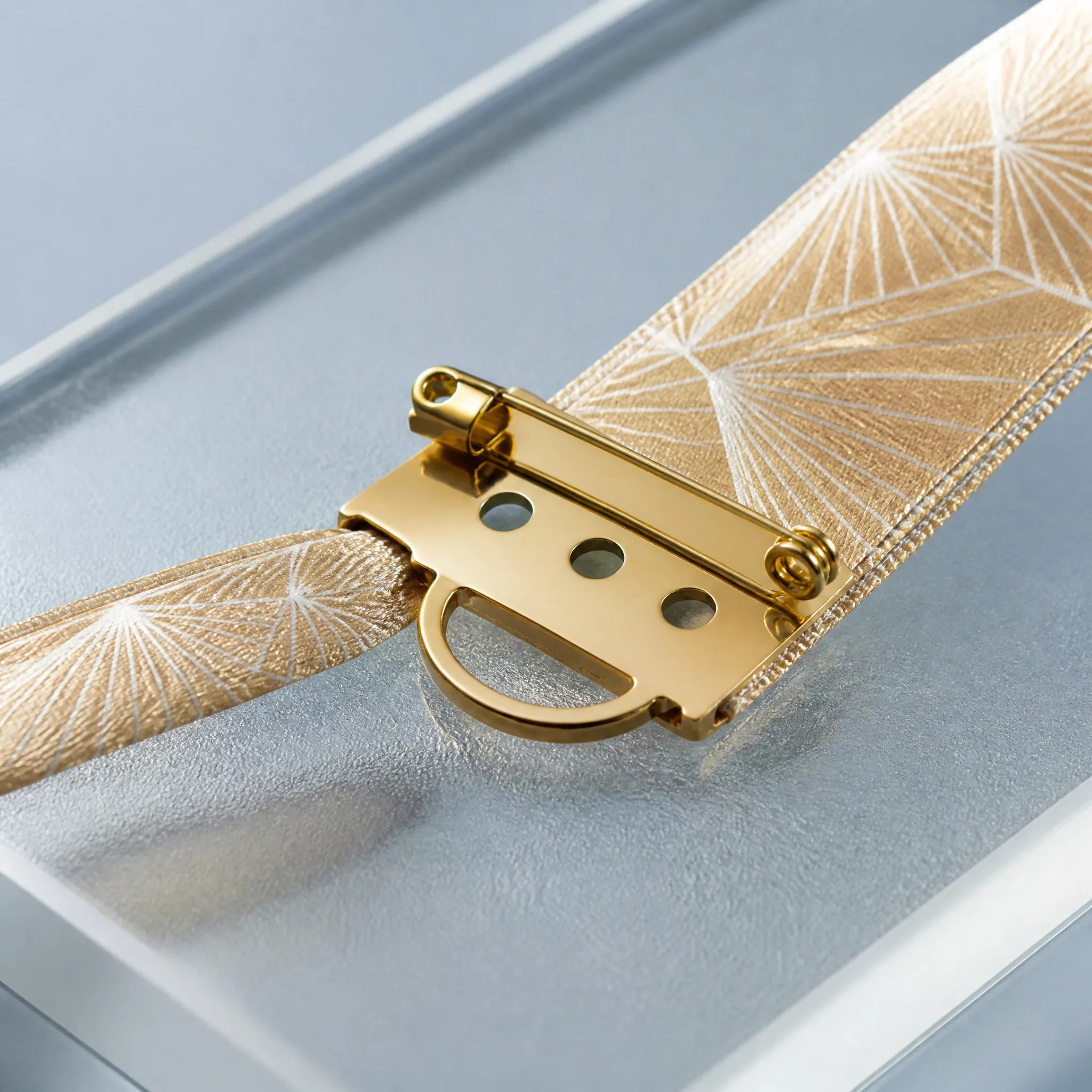 Close-up of silky satin texture and gold safety pin badge holder mechanism