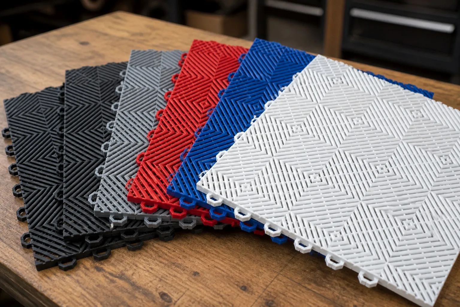 Interlocking garage floor tile samples in multiple colors arranged on a table