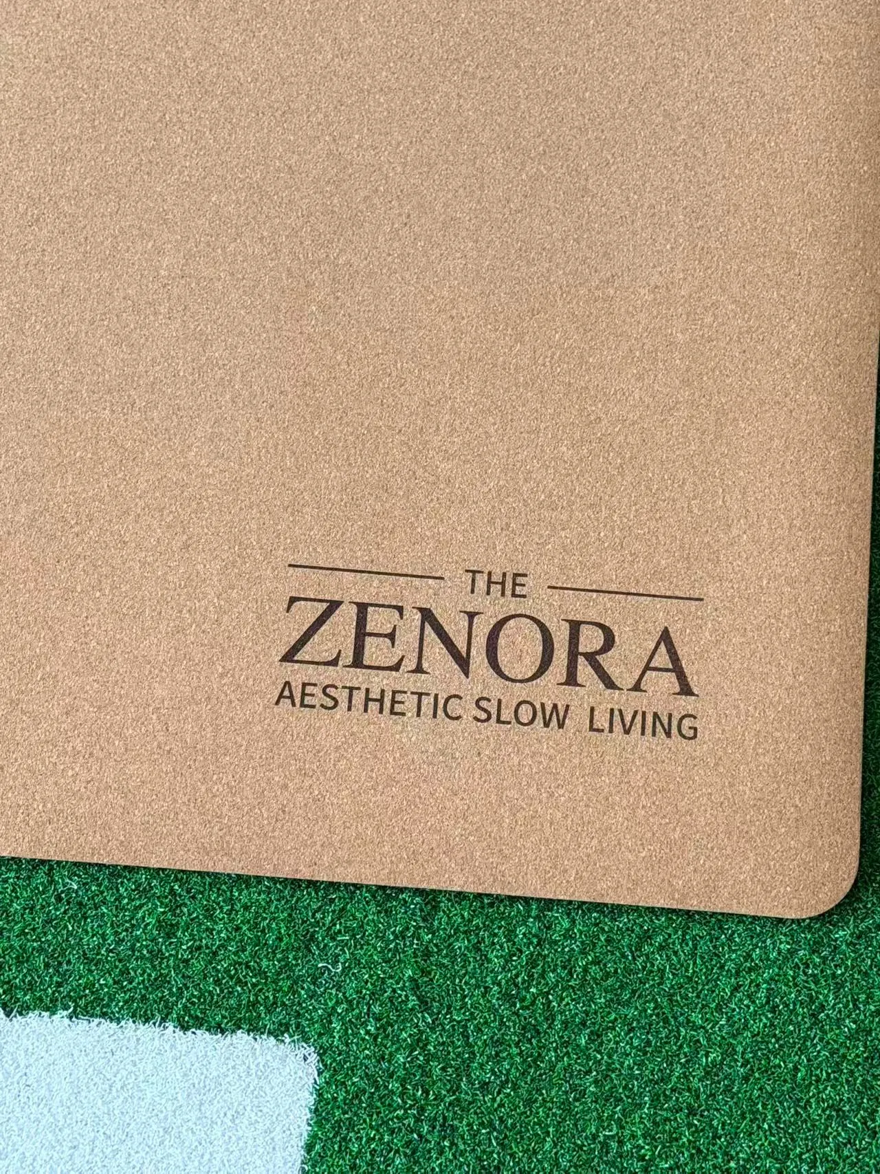 Zenora brand logo detail on cork mat surface