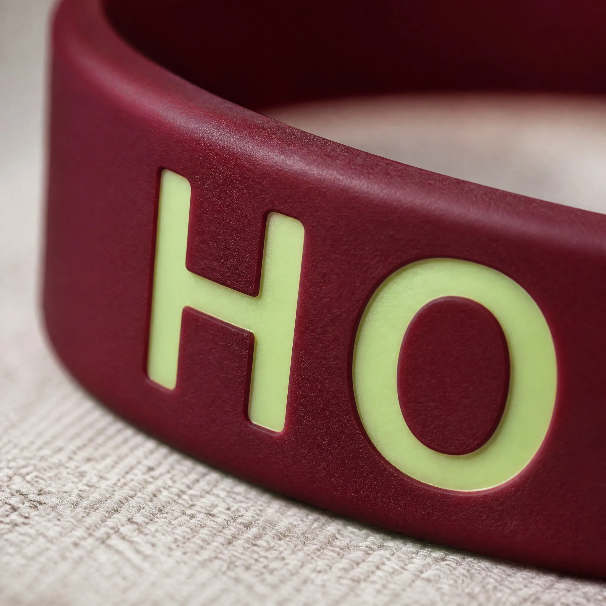 Macro detail of phosphorescent glow pigment lettering on silicone bracelet