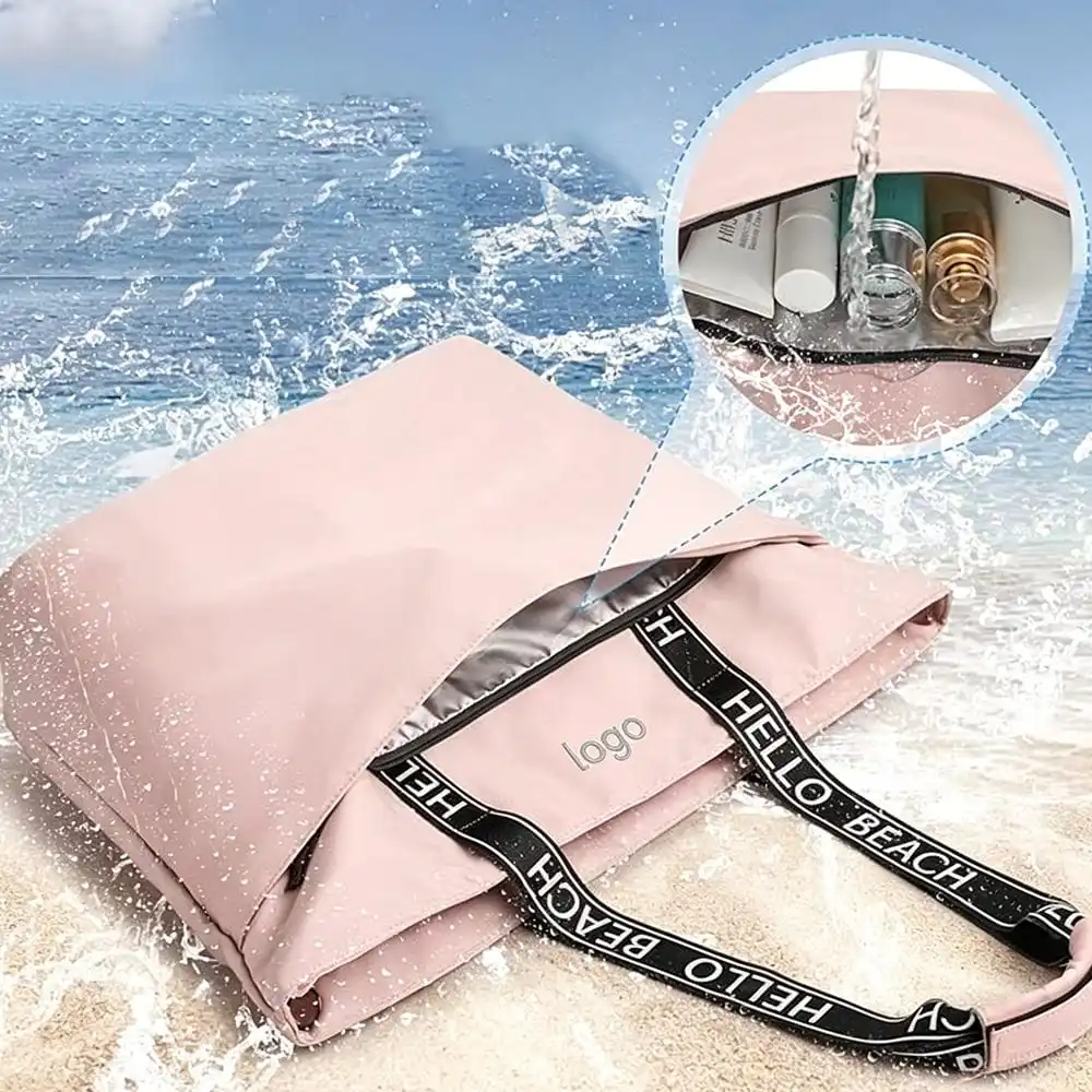 Pink waterproof beach tote with printed logo strap in surf
