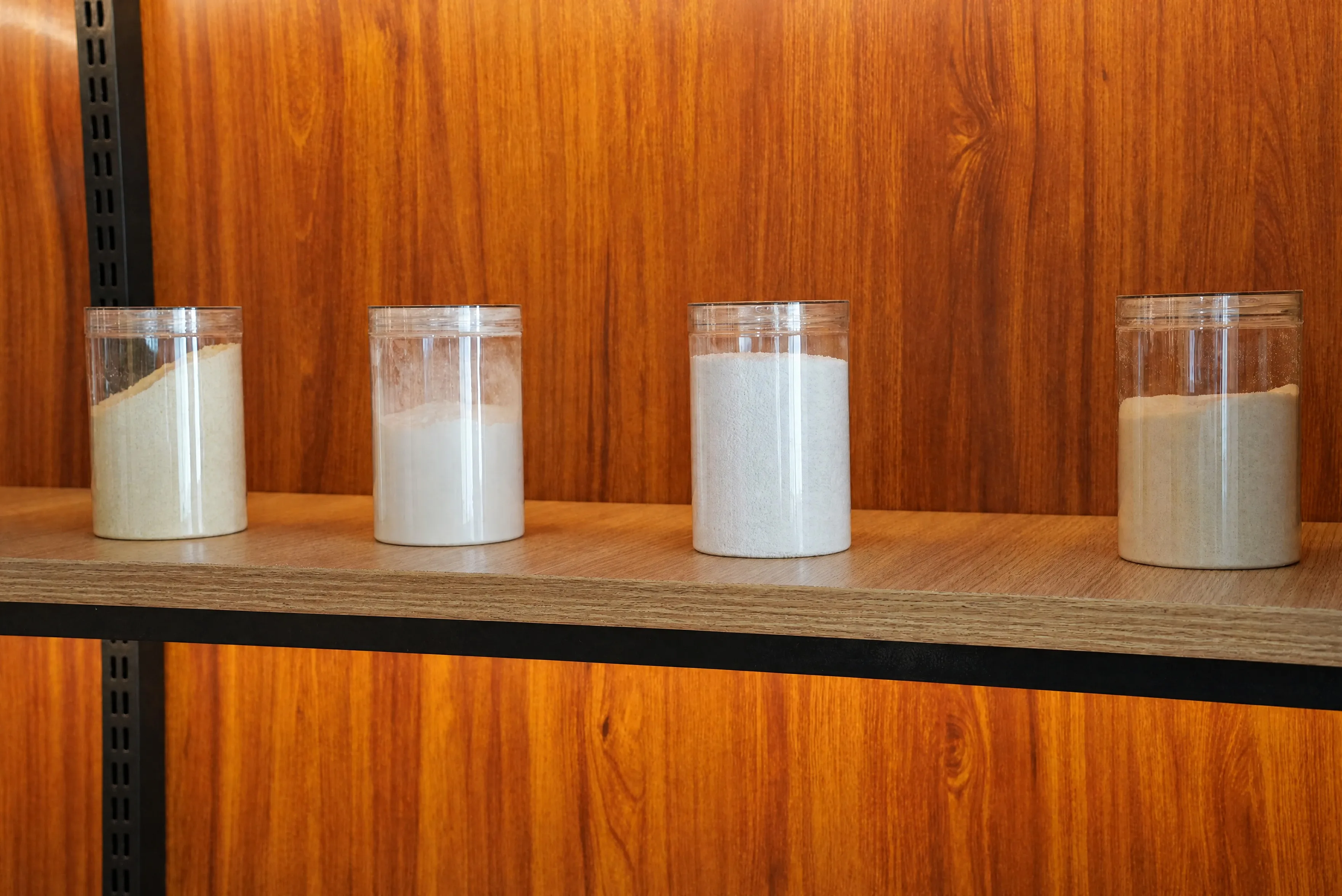 Cat litter formula raw materials - corn flour, guar gum, baking soda and soybean fiber in sample jars