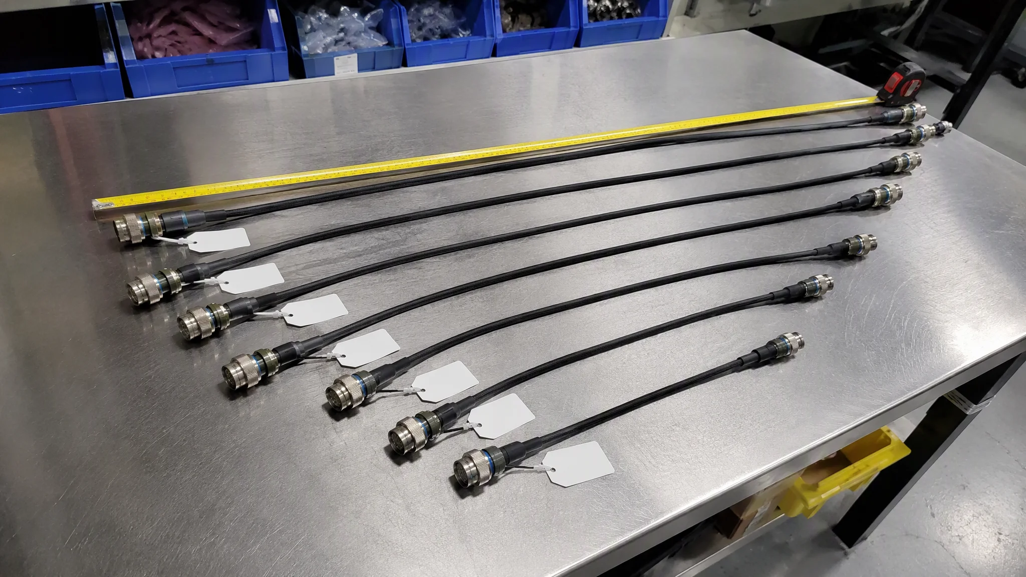 Finished custom cable assemblies of different lengths laid out on a workbench