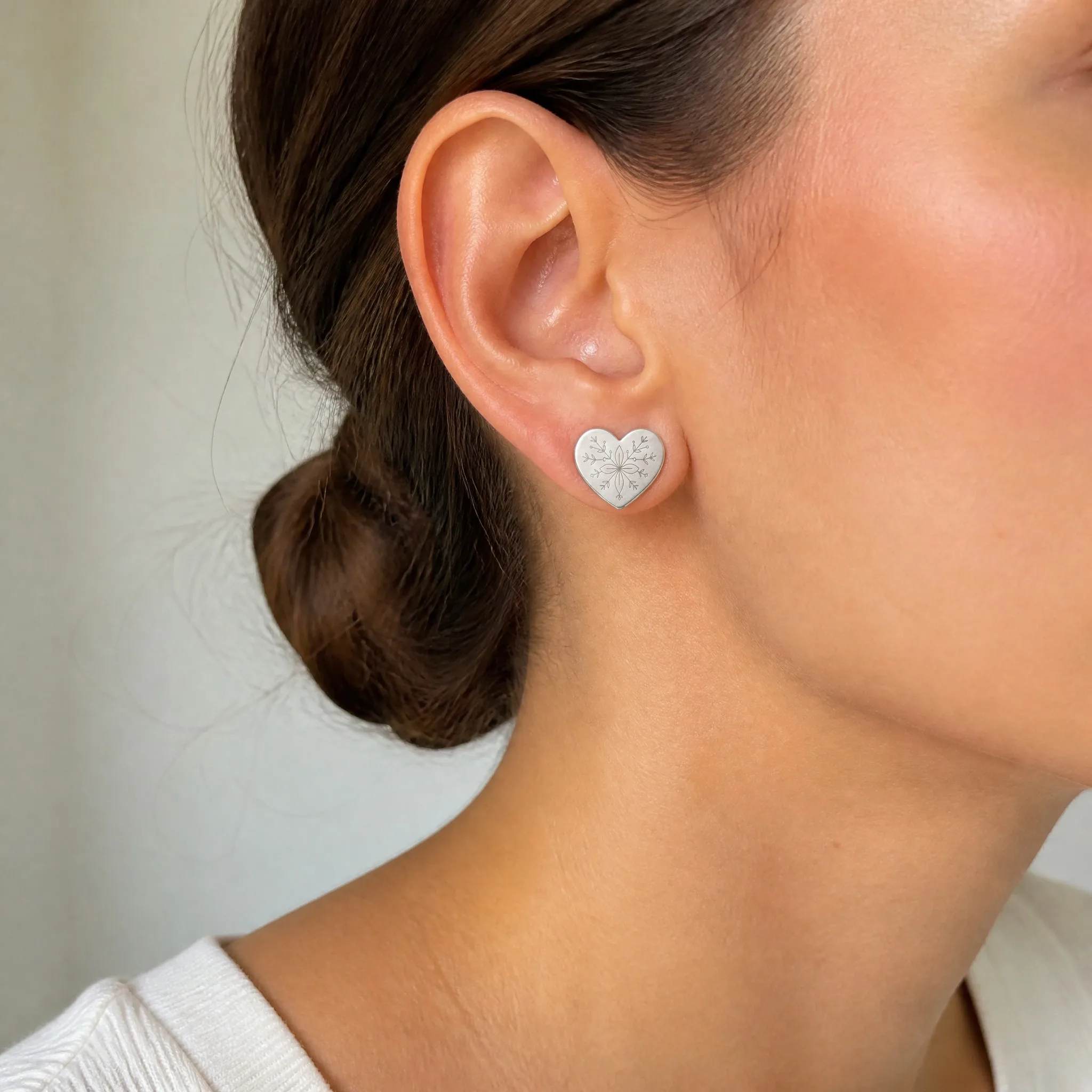 Wearing laser engraved heart earrings