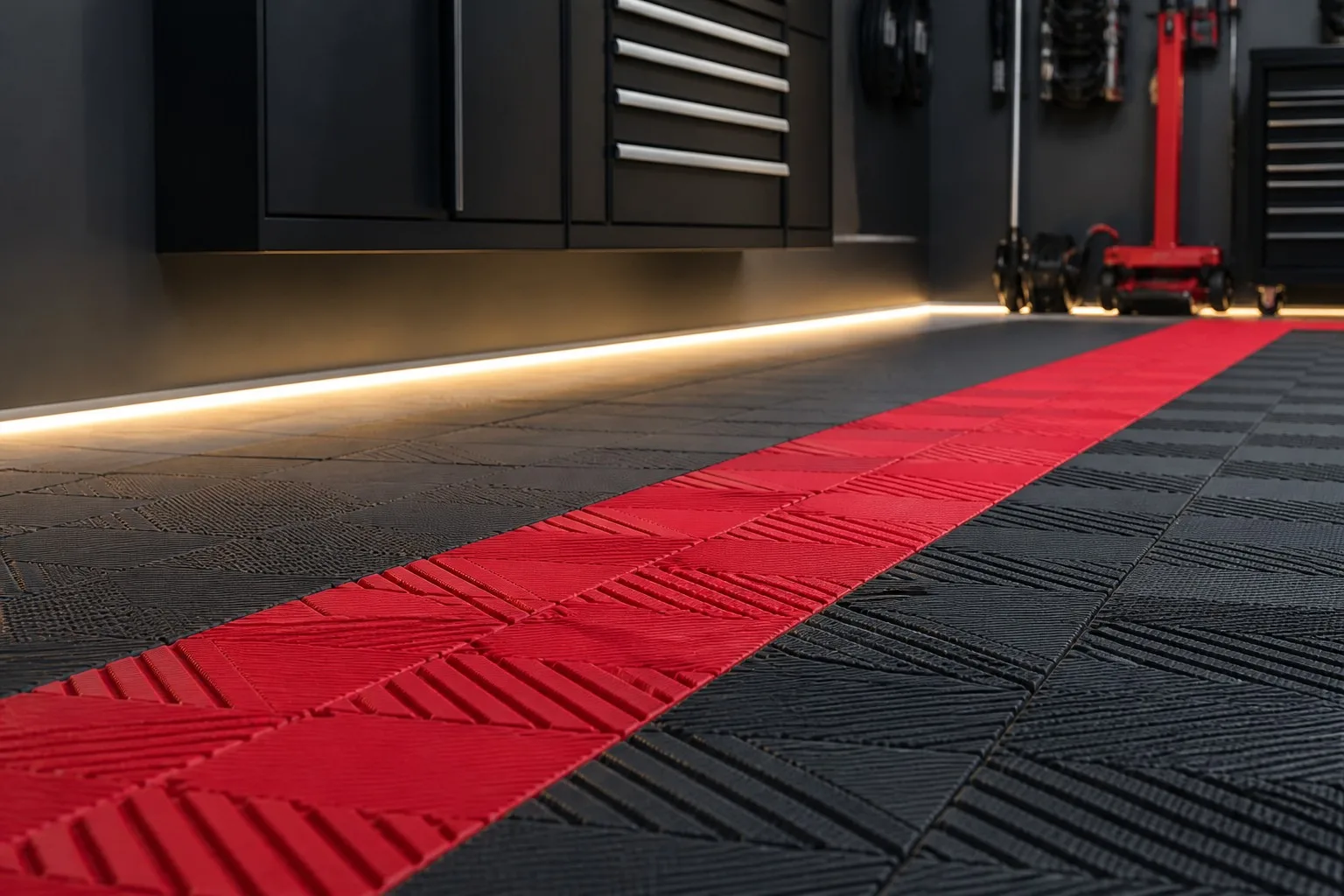 Dark gray garage floor tiles with a red racing stripe pattern and LED accent lighting