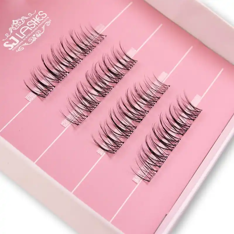 Close up of a pale paper tray insert printed with the brand mark and three rows of lash clusters held in place, inside a pink lash box - printed paper tray insert