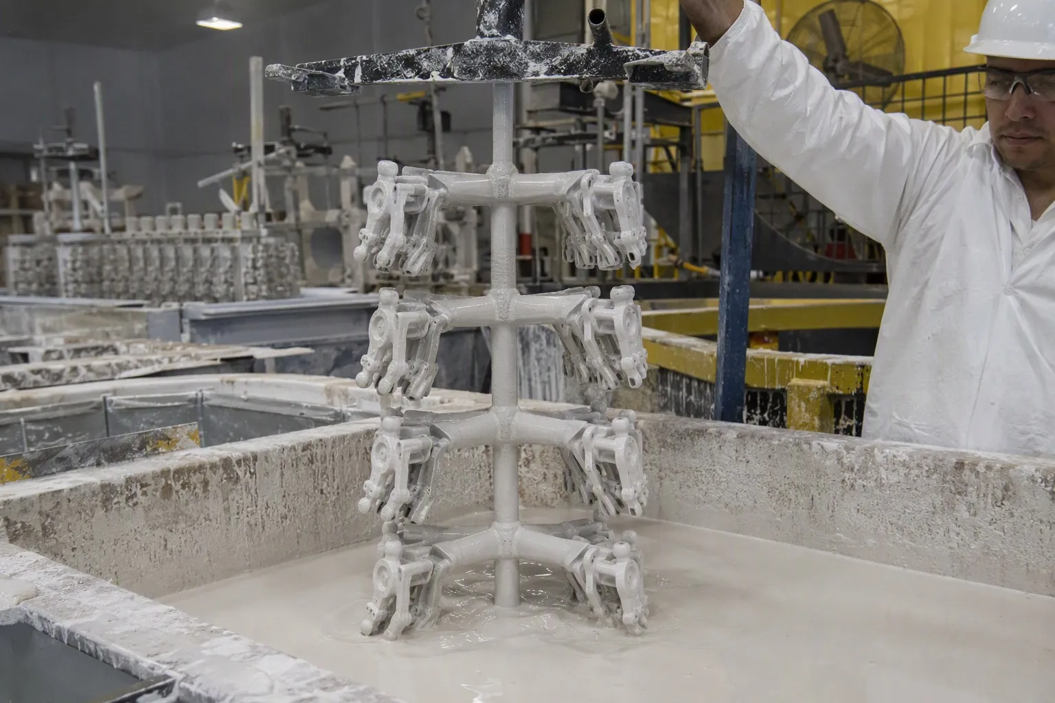 Investment casting wax pattern tree being dipped in ceramic slurry during shell building