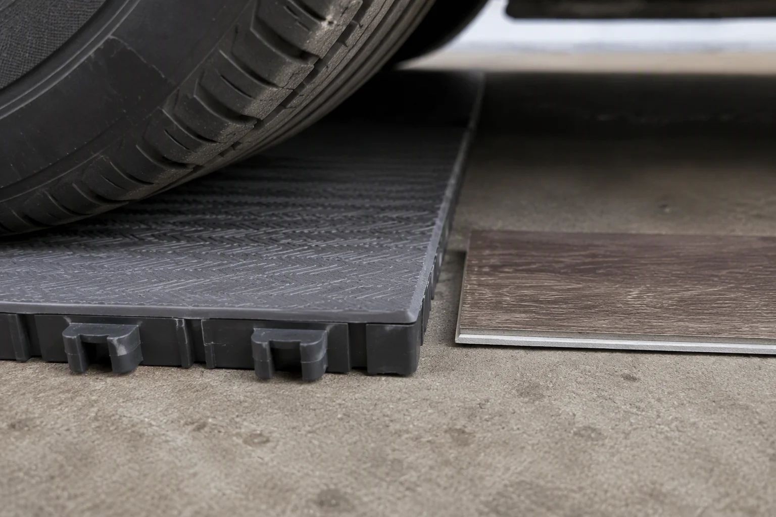 Close-up comparing thick interlocking garage floor tile edge with thin vinyl plank