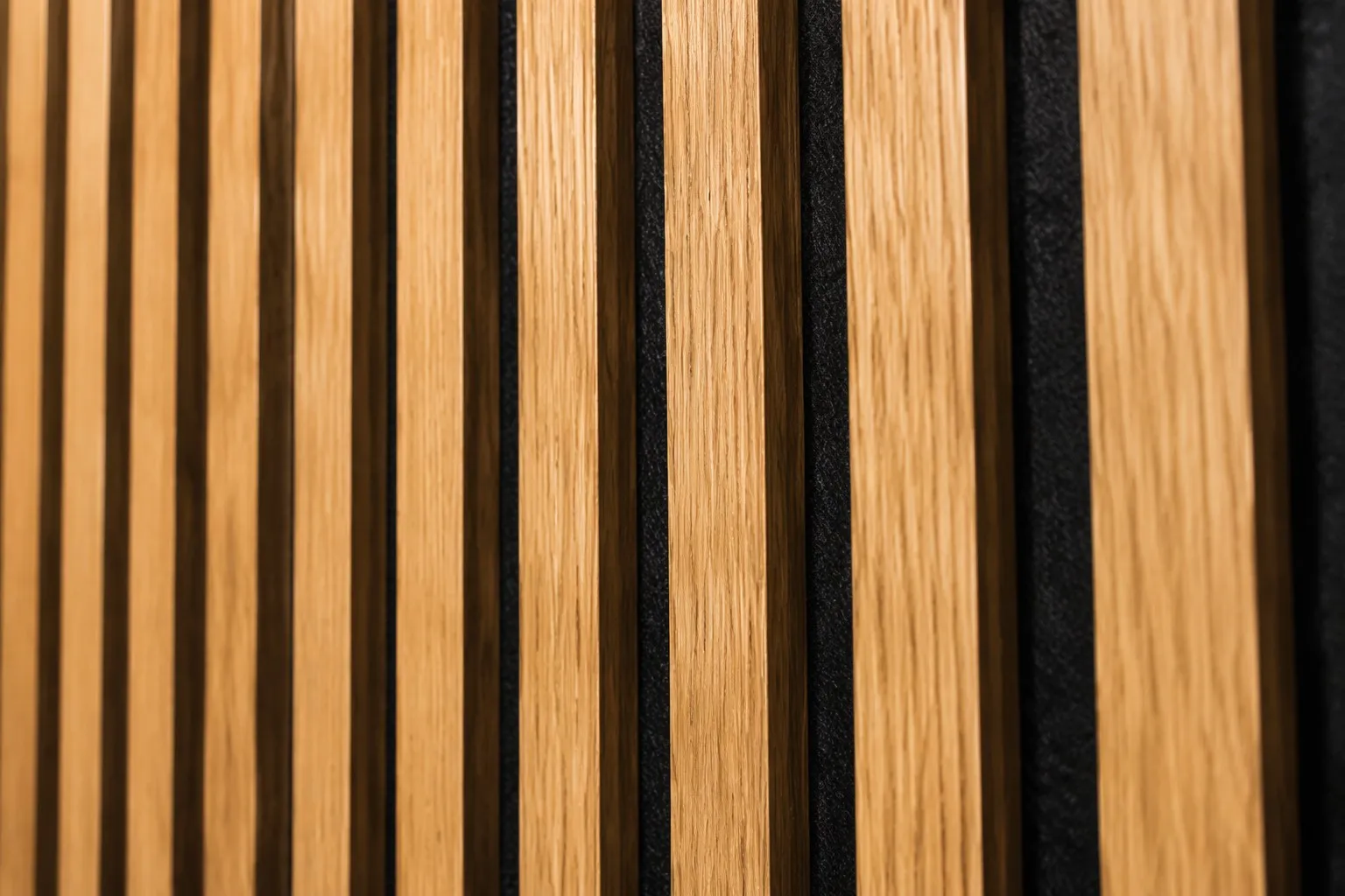 Close-up detail of wood slat acoustic panels showing natural oak wood grain texture and black acoustic felt backing between slats