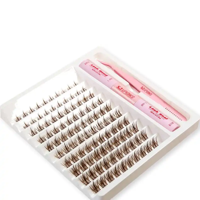 White molded lash kit tray at an angle showing ten rows of lash clusters, two tube channels and a long tool channel, with the pink bond and seal tubes and the dual-ended tool in place - molded lash kit tray