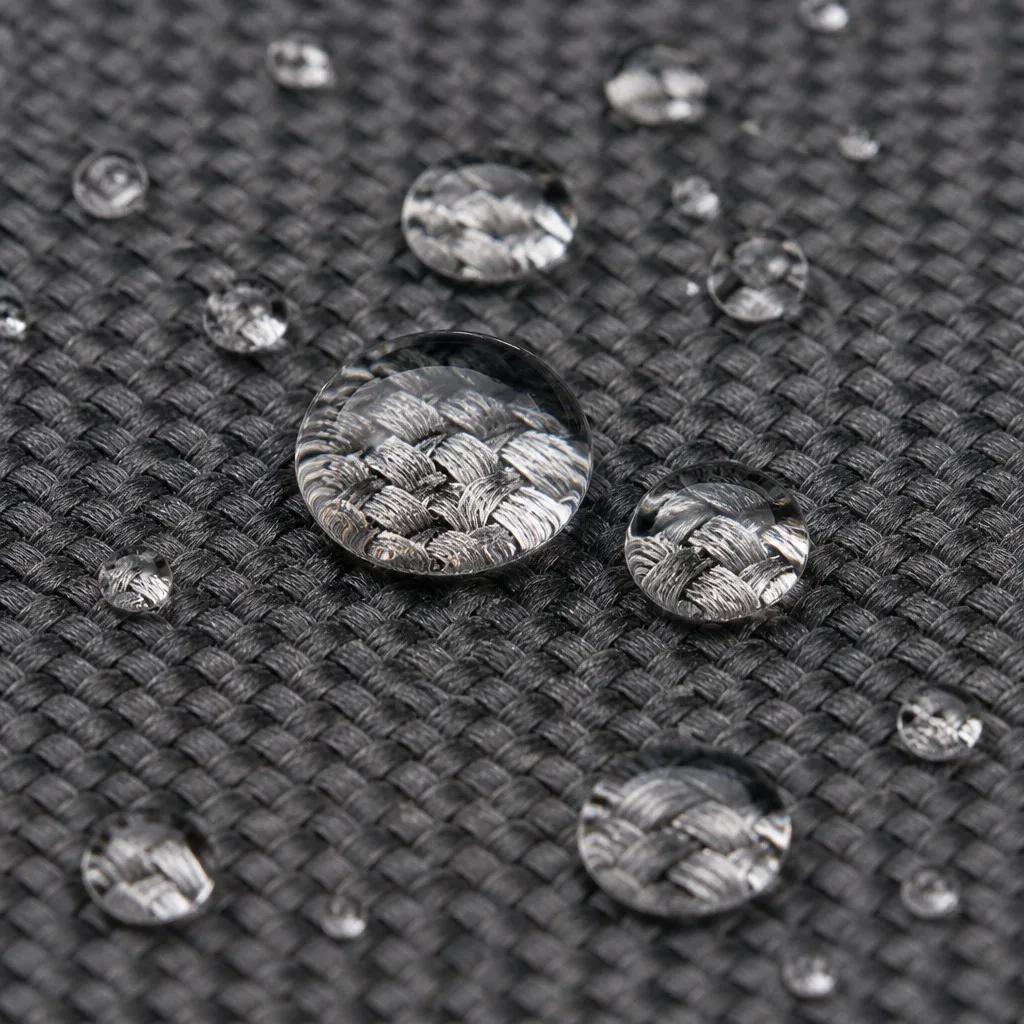 Water droplets beading on the matte water-repellent surface of charcoal oxford fabric