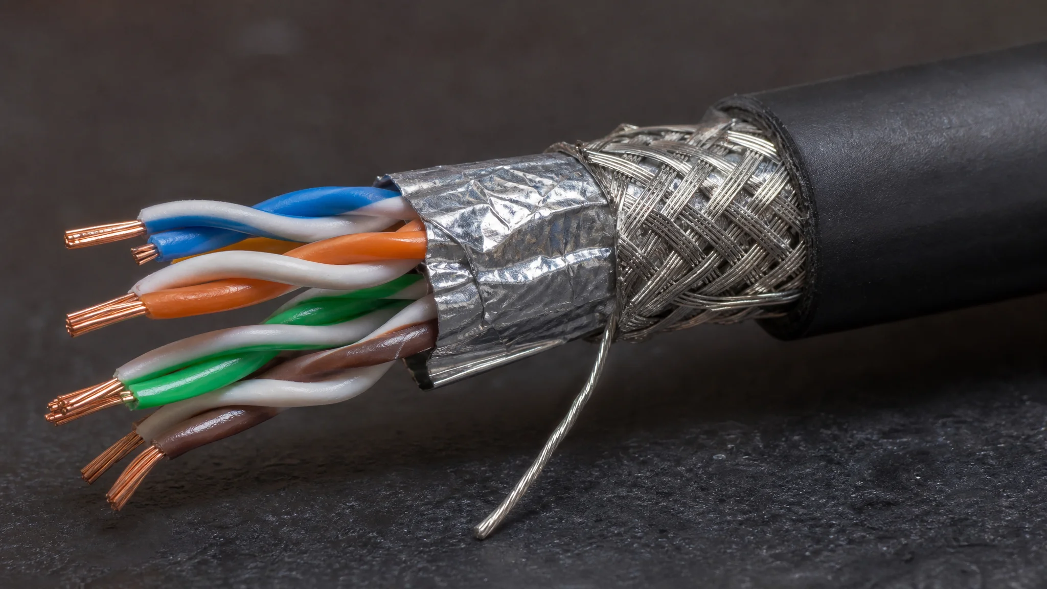 Macro cross-section of a shielded ethernet cable showing twisted pairs, foil and drain wire