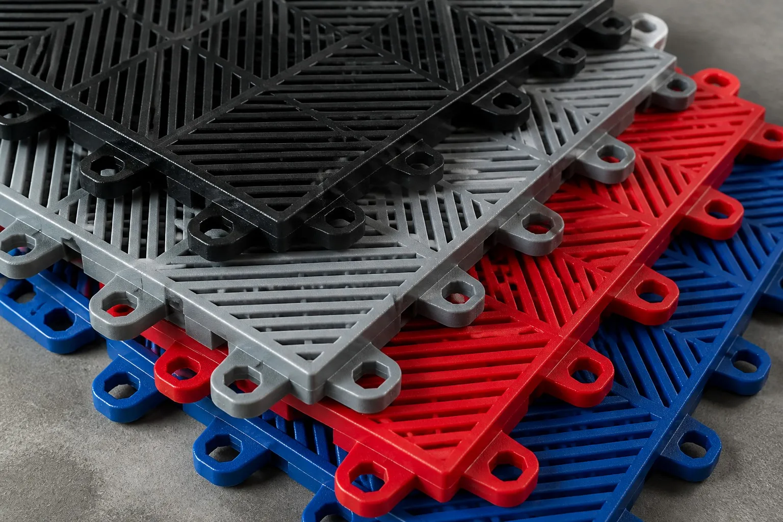 Interlocking garage floor tiles with drainage channels in multiple colors