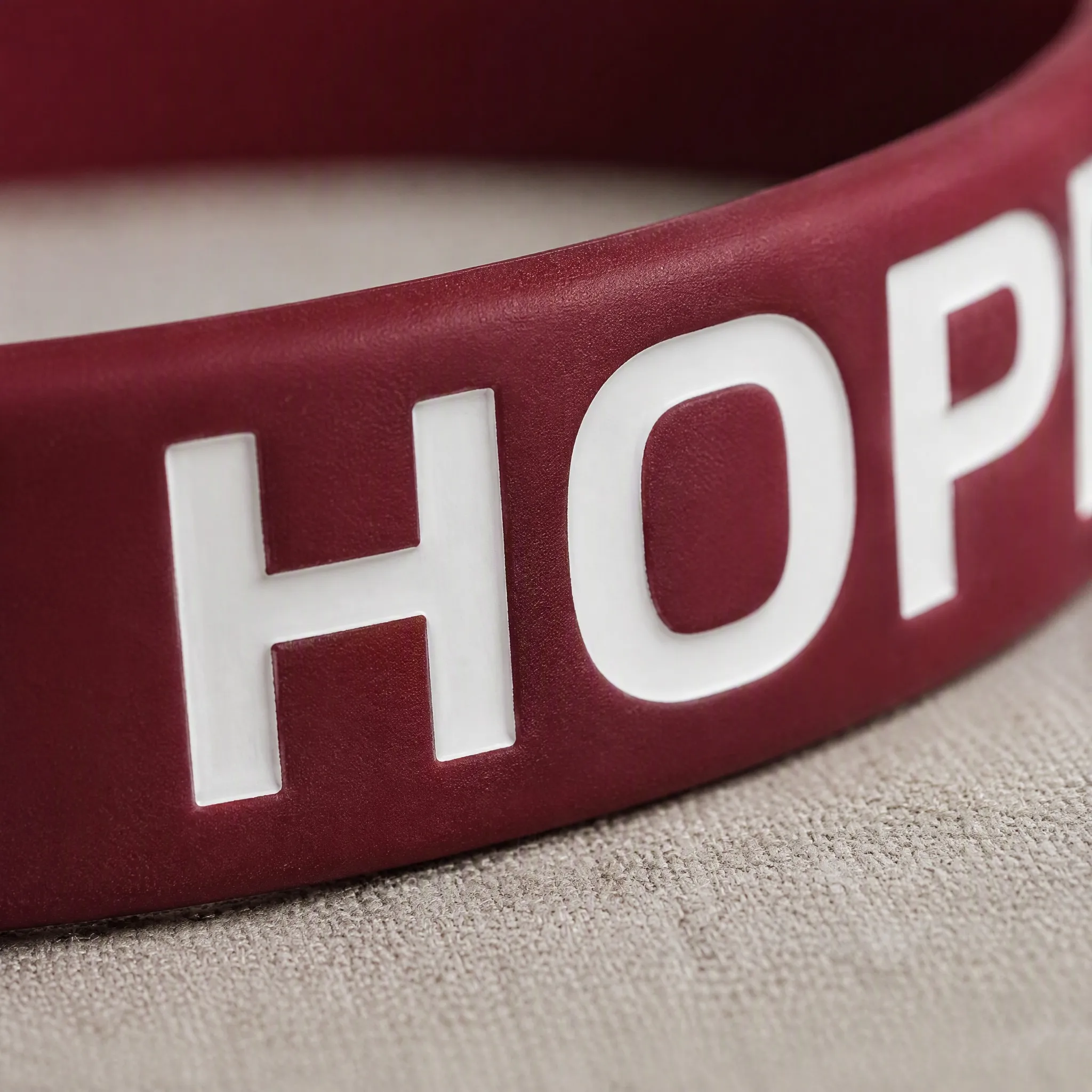 Macro detail of white ink filled lettering on silicone bracelet