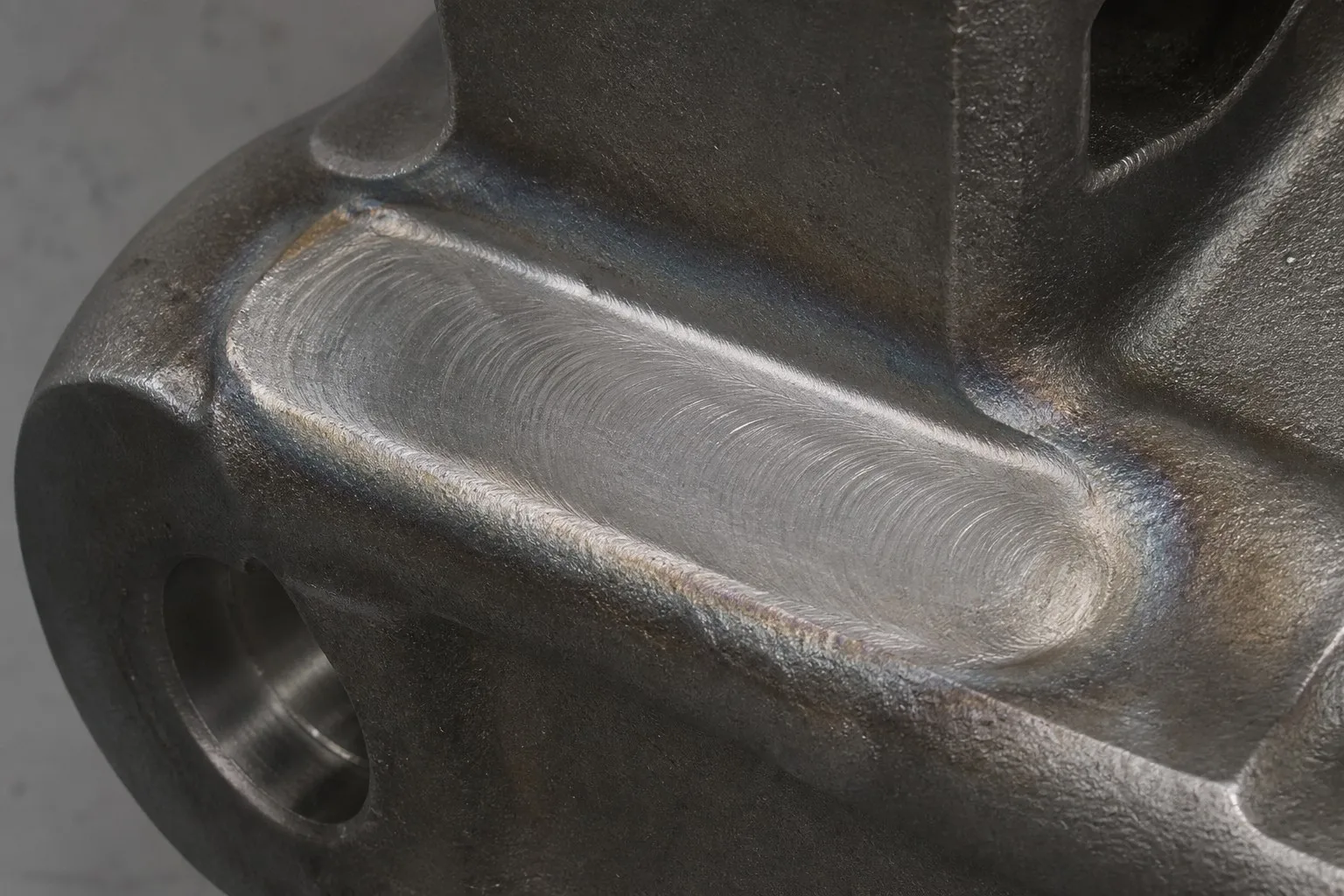 Completed and ground weld bead on steel casting showing ripples and HAZ