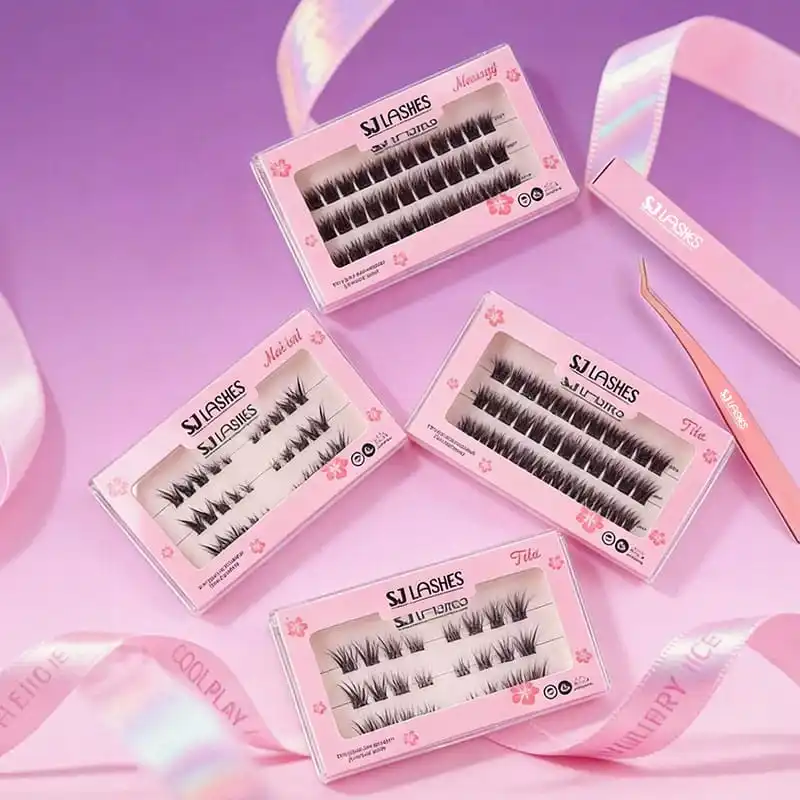 Pink lash boxes with clear windows and hibiscus print arranged on a lilac background with iridescent ribbon, showing style names and vegan and handmade badges - lash sleeve packaging with foil finishing