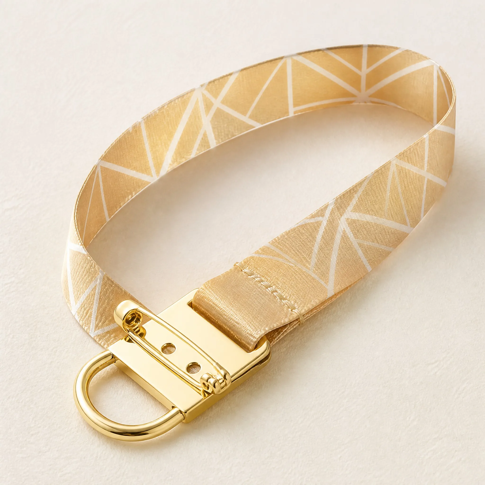 Neat loop of satin lanyard showing gold safety pin holder and D-ring