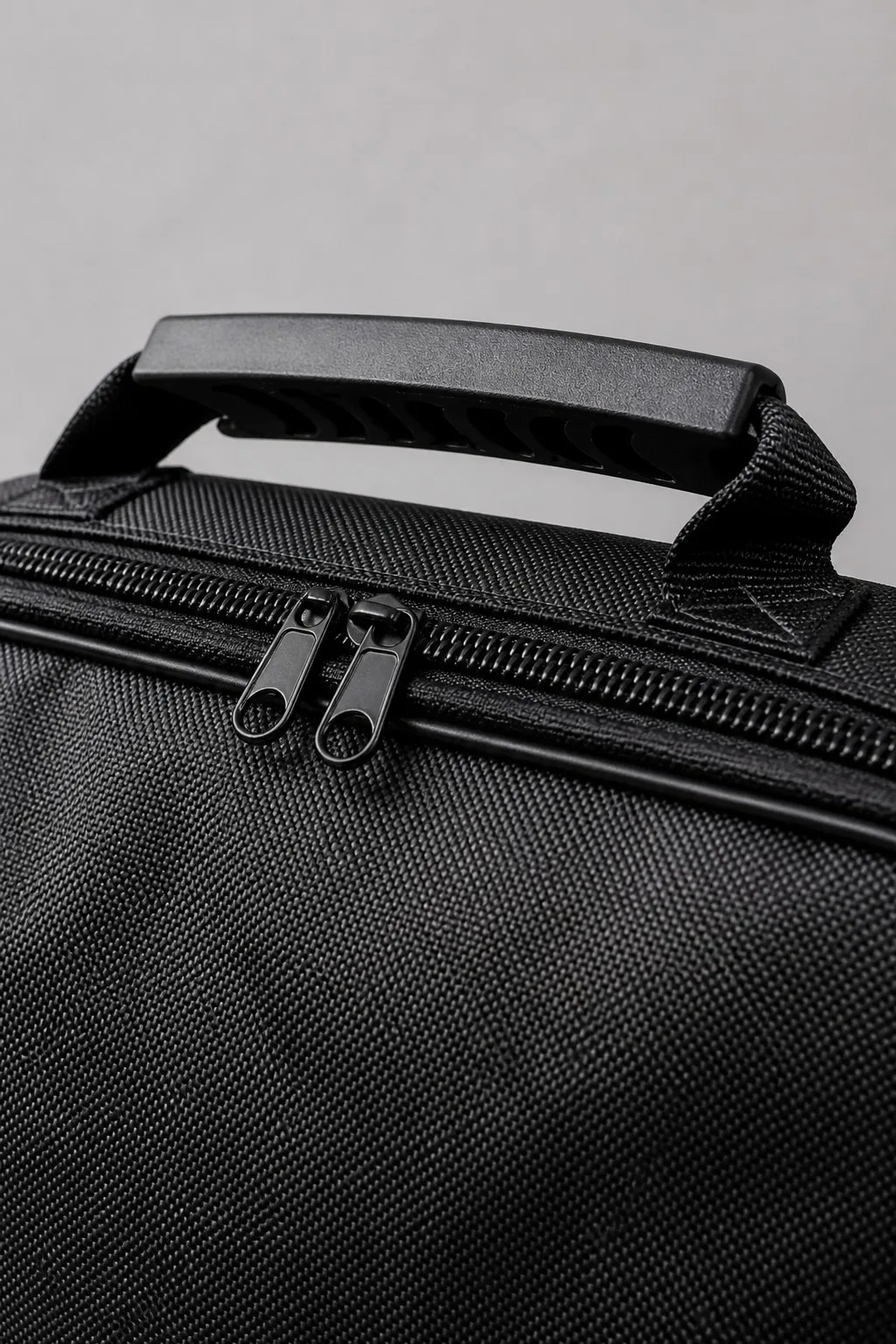 Close-up of MotiveX storage bag's reinforced carrying handle and thick dual-zipper stitching