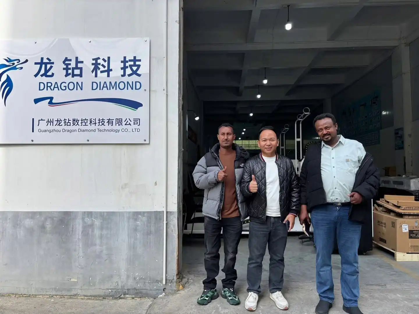 Ethiopian team thumbs up at Dragon Diamond factory gate