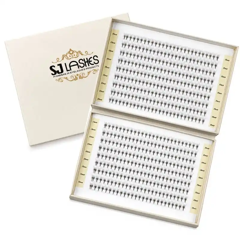 Cream bifold lash gift box open at an angle, brand wordmark and gold flourish on the lid, two dense lash trays on printed panels - bifold lash gift box