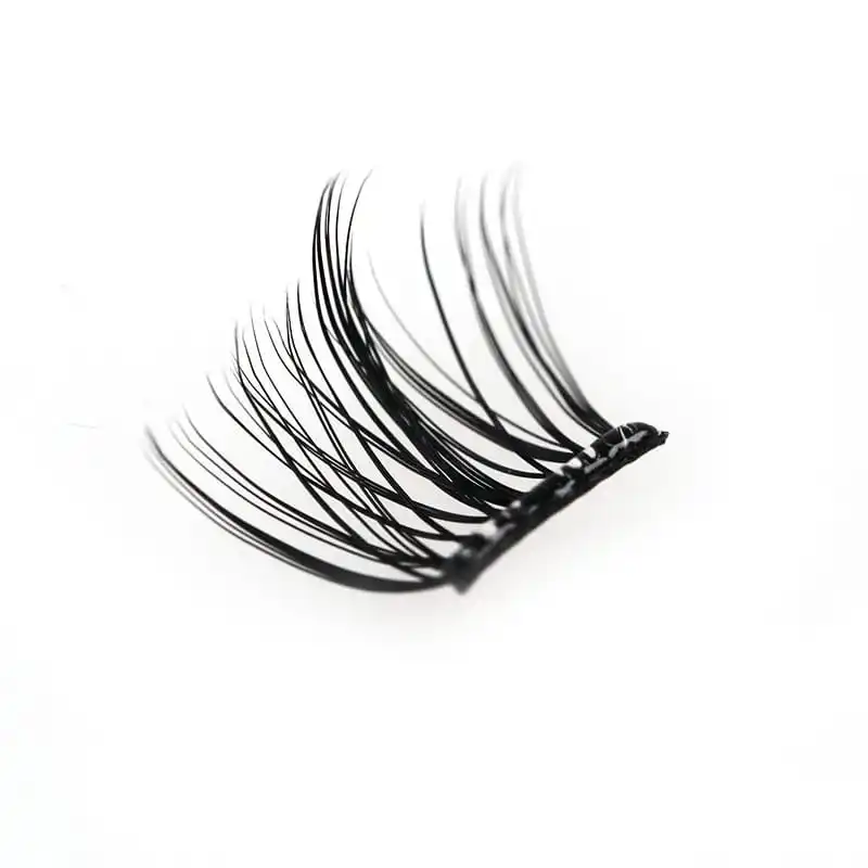 Macro photograph of a single black lash segment fan on a white background showing the flat bonded base and individual fibre tips - glue free segment lashes