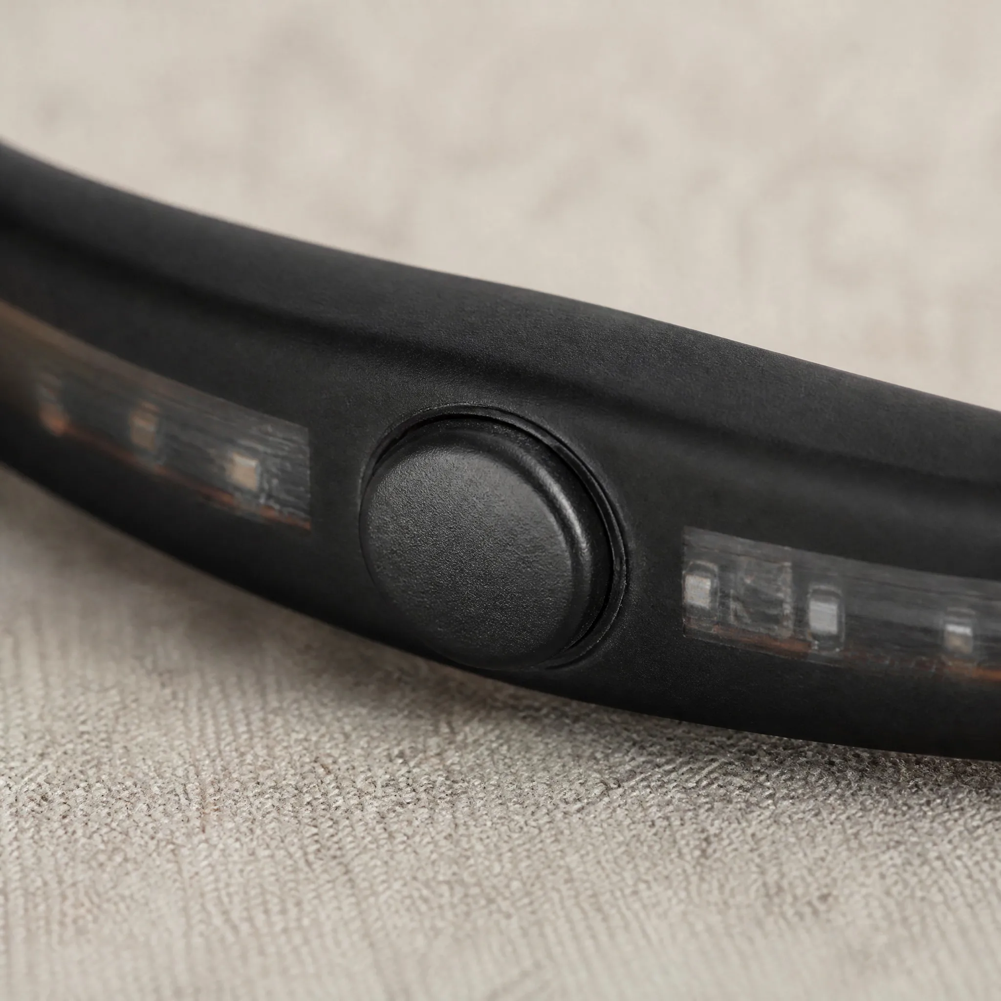 Macro detail of the waterproof button and internal LED strip on the bracelet