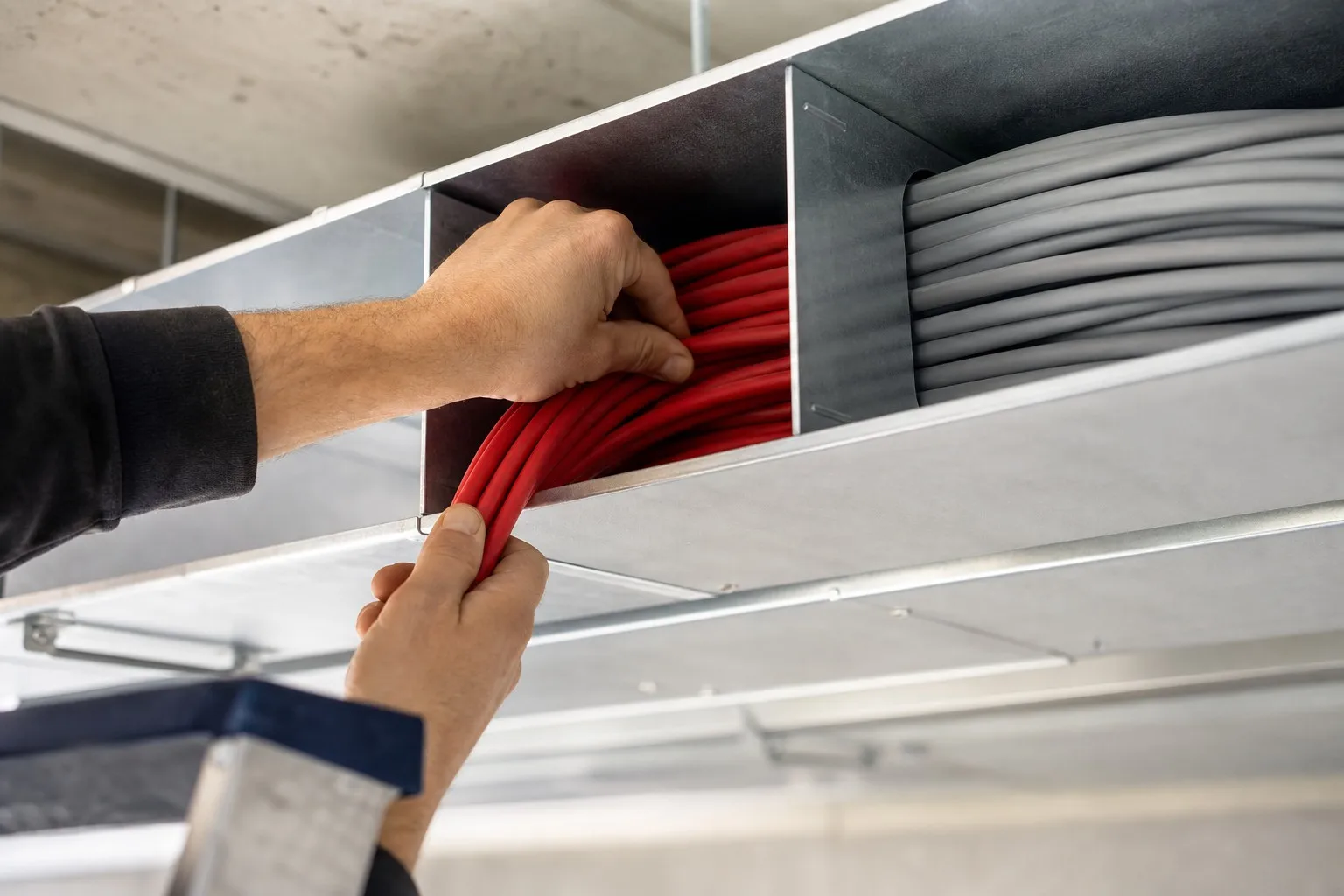 Cable segregation in practice — fire alarm cable in its own trunking compartment, separate from power cables