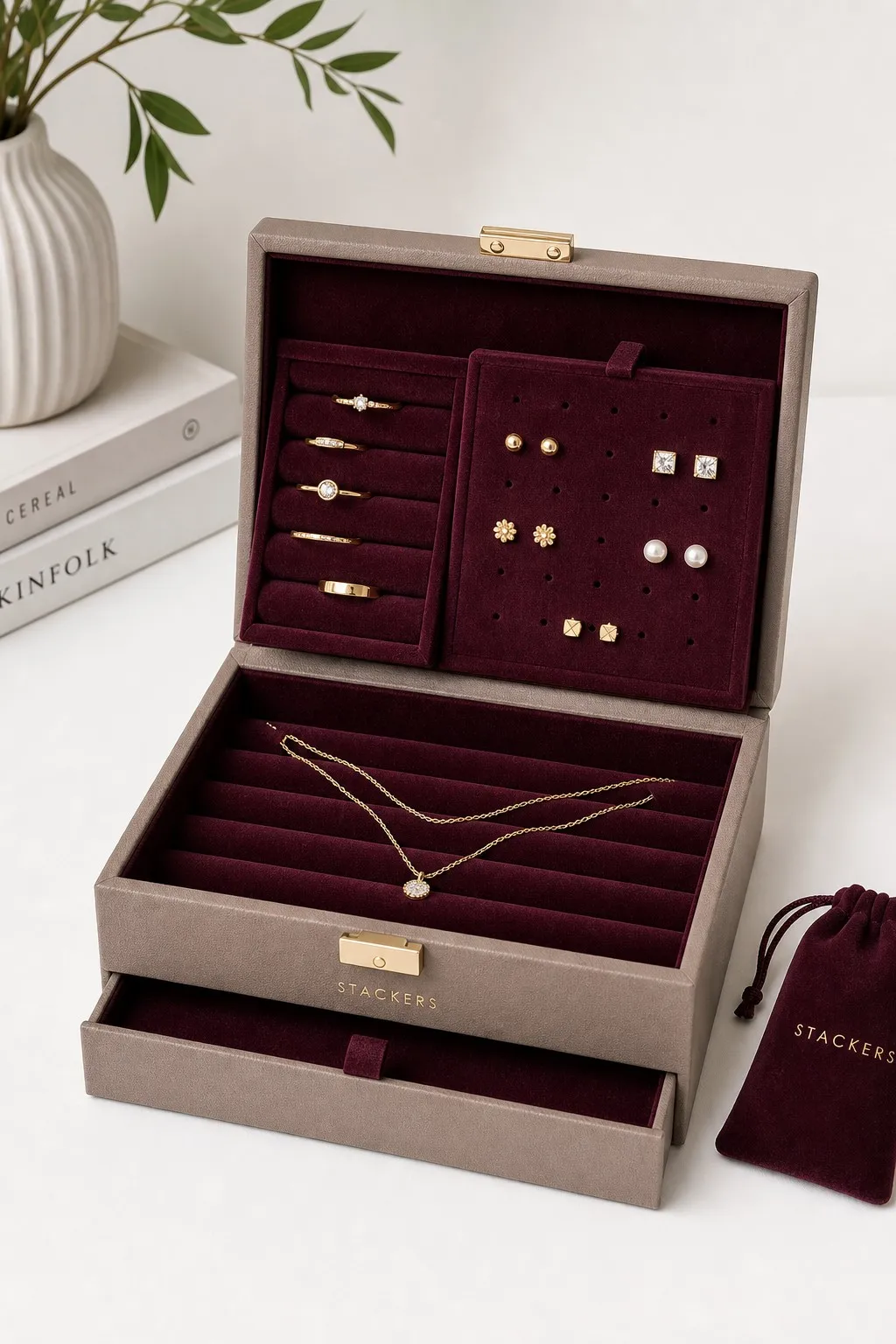 Open two-layer jewelry organizer box with burgundy velvet lining, ring slots, earring panel, and necklace compartments