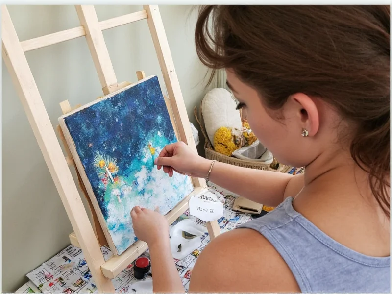 Artist using completed DIY easel with canvas and supplies