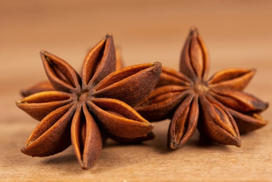 Close-up photograph of whole star anise pods showing their distinctive star shape and reddish-brown color against a wooden kitchen surface