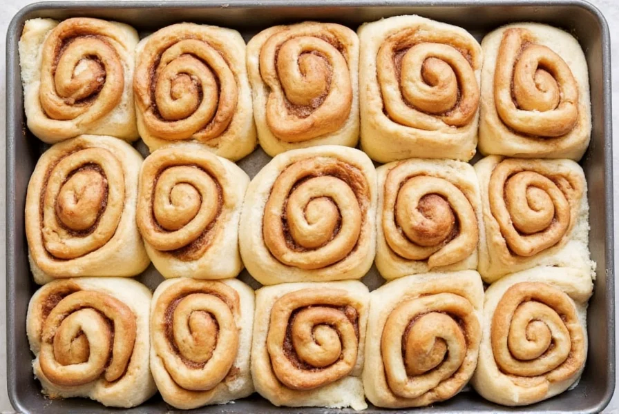 Professional copycat Cinnabon cinnamon rolls with perfect spiral swirls on baking sheet