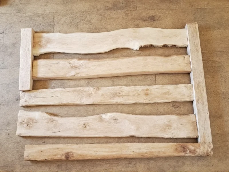 Reclaimed wood pieces laid out for DIY canvas frame construction