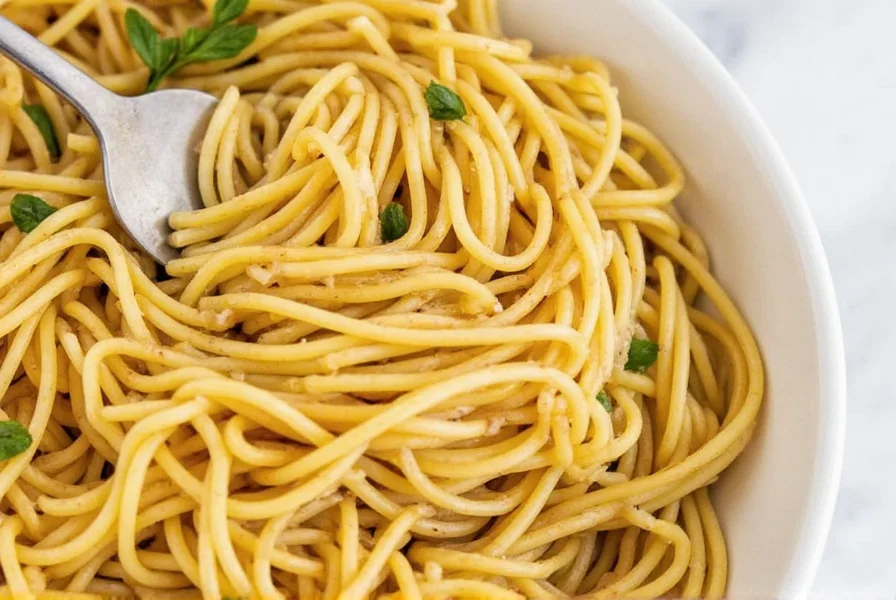 Spaghetti with pesto and red pepper flakes served in a white bowl