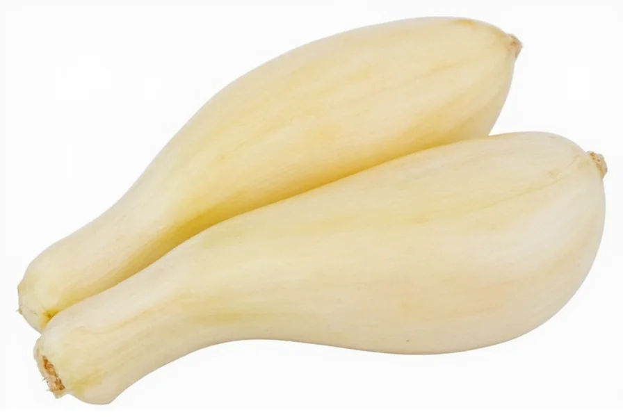 Three medium garlic cloves next to one tablespoon of minced garlic for visual measurement comparison