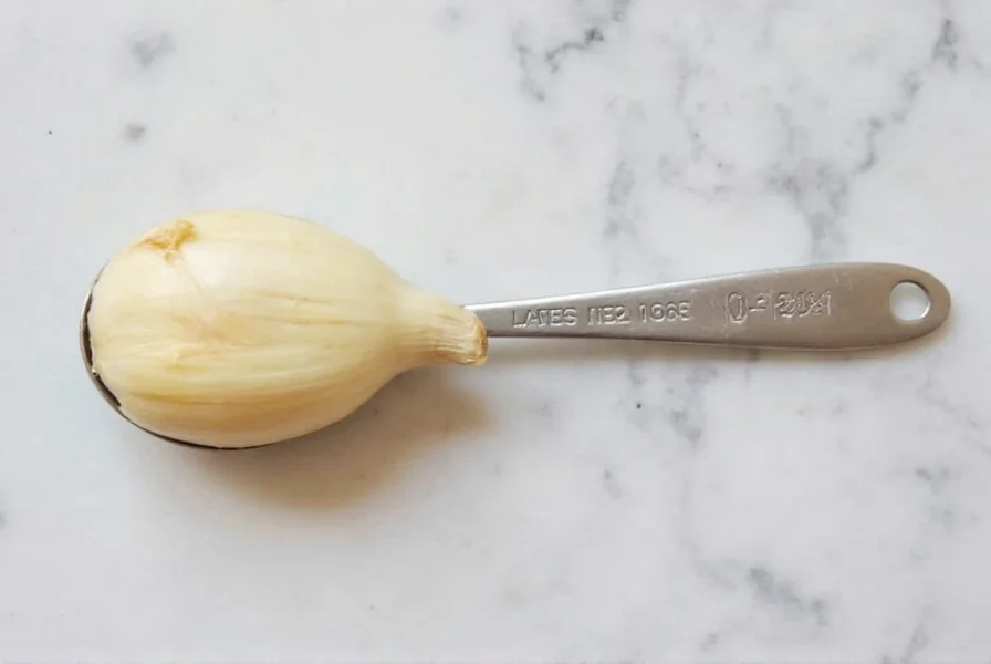 Garlic cloves next to teaspoon measurement showing minced garlic equivalent