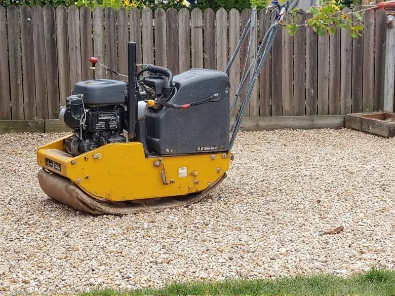 Gravel base for concrete patio being compacted with plate compactor