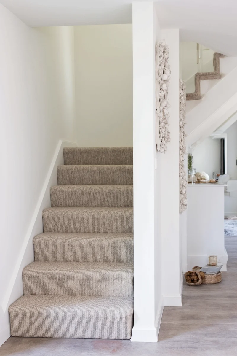 Floating shelves and framed photos on staircase wall