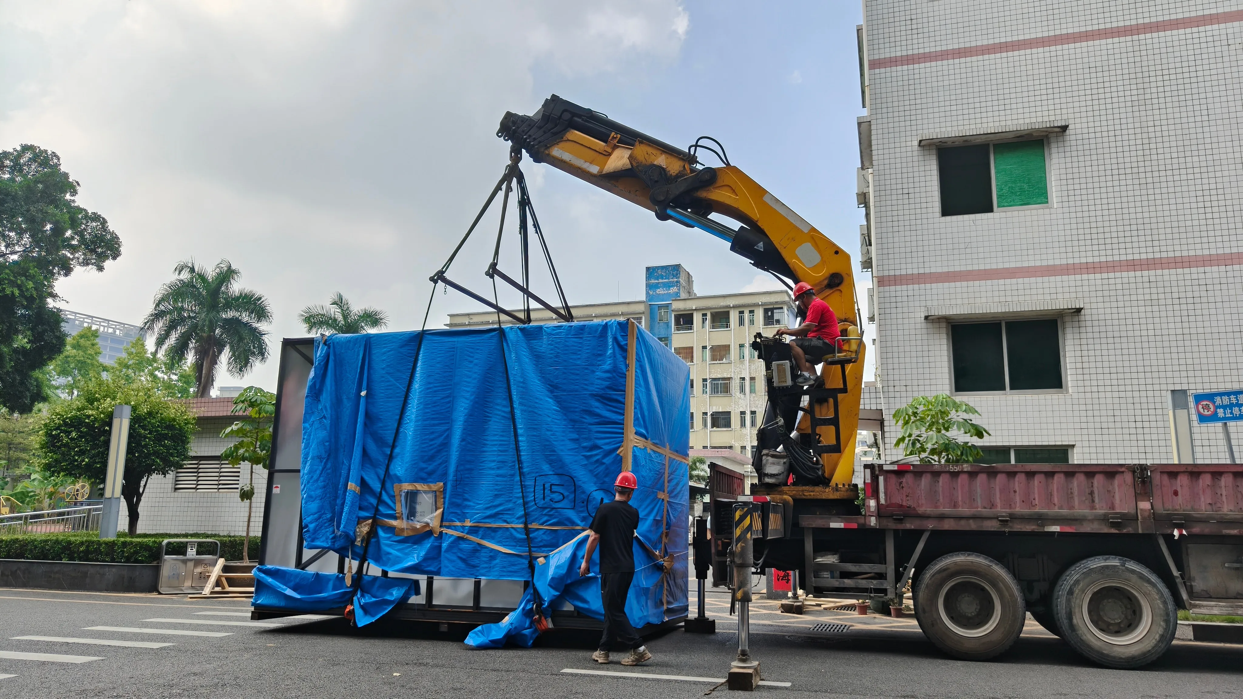 Unloading the Mazak VARIAXIS i-700 NEO with a truck-mounted crane at the Shenzhen factory