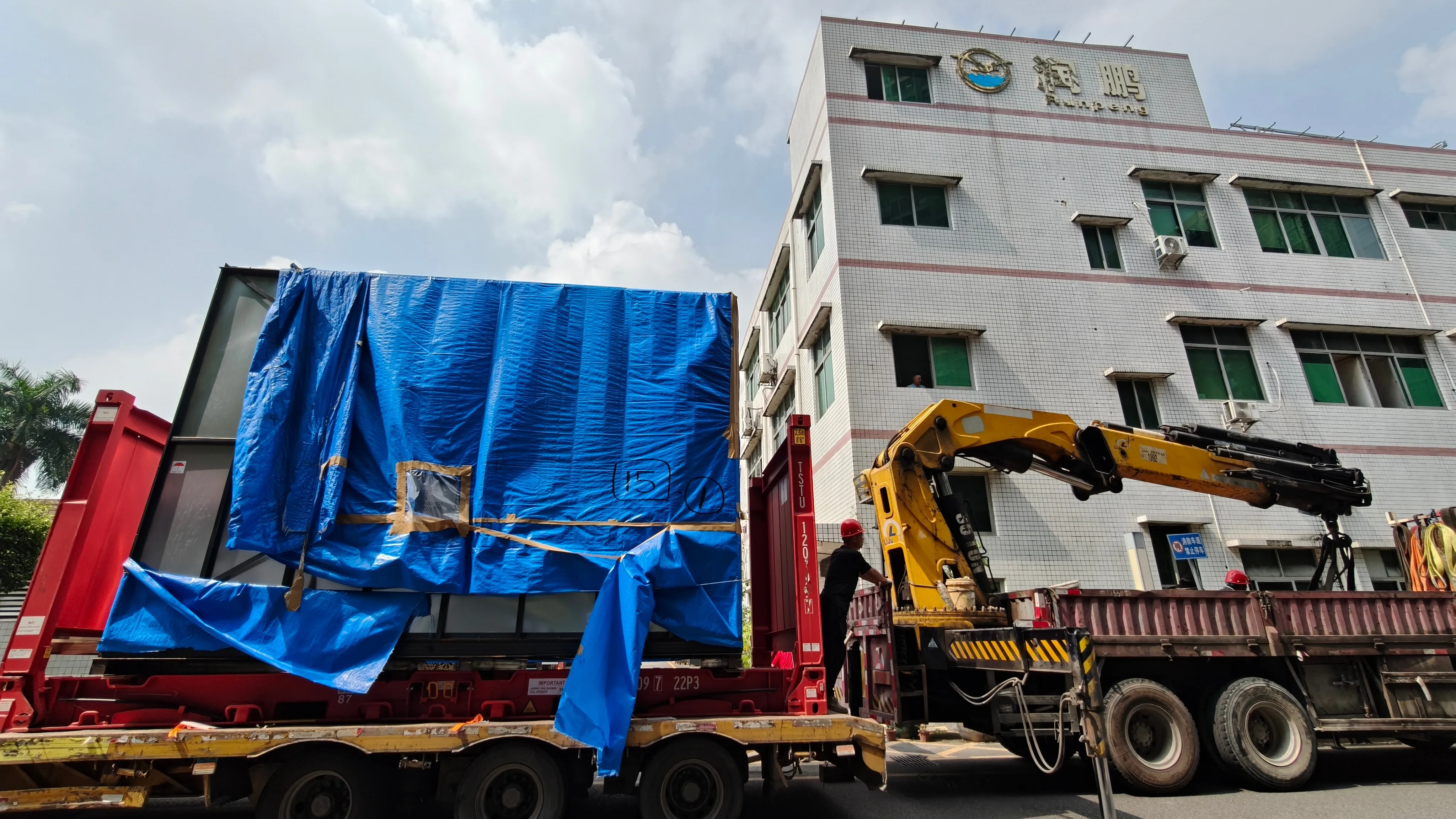 Mazak 5-axis machining center delivered on a low-bed trailer in front of the Runpeng factory building