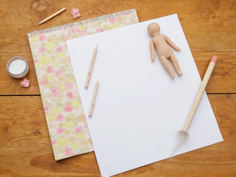 Paper doll materials on wooden table