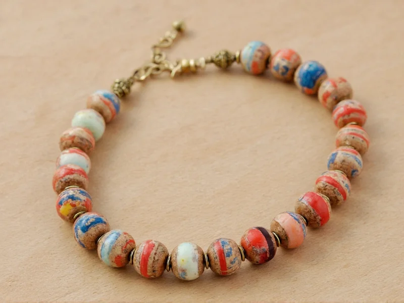 Finished recycled paper bead jewelry on natural wood background