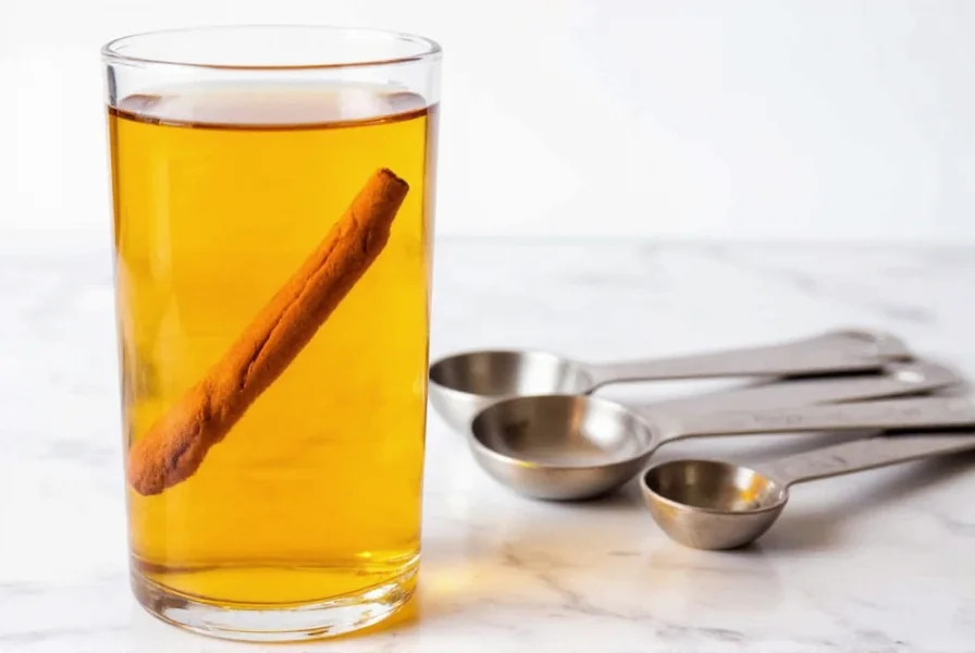 Glass of diluted apple cider vinegar with cinnamon stirred in, next to measuring spoons
