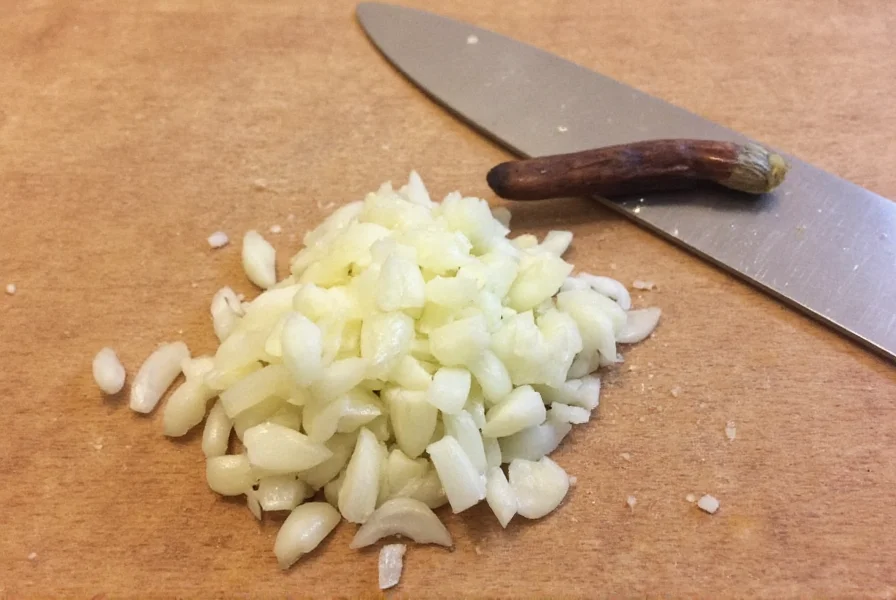 Chef measuring minced garlic in teaspoon