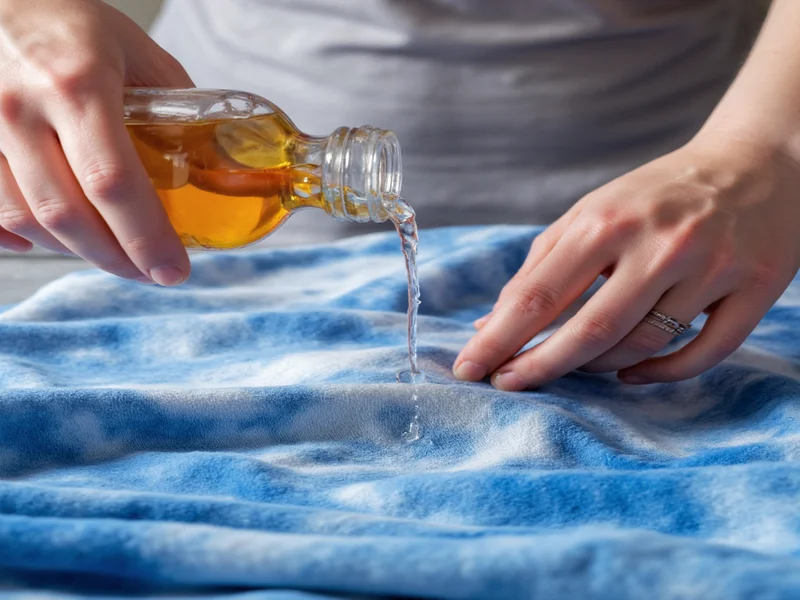 Hands applying vinegar solution to fabric during fading process
