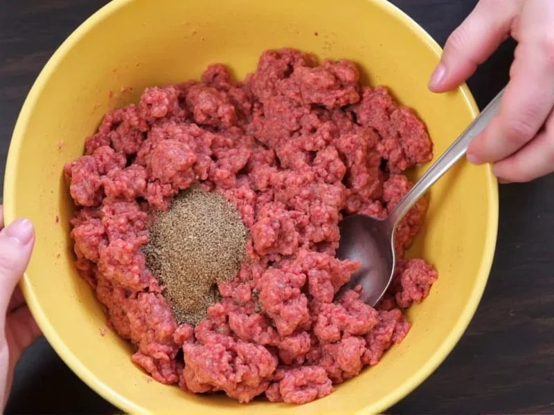 Hand mixing ground beef with homemade burger seasoning
