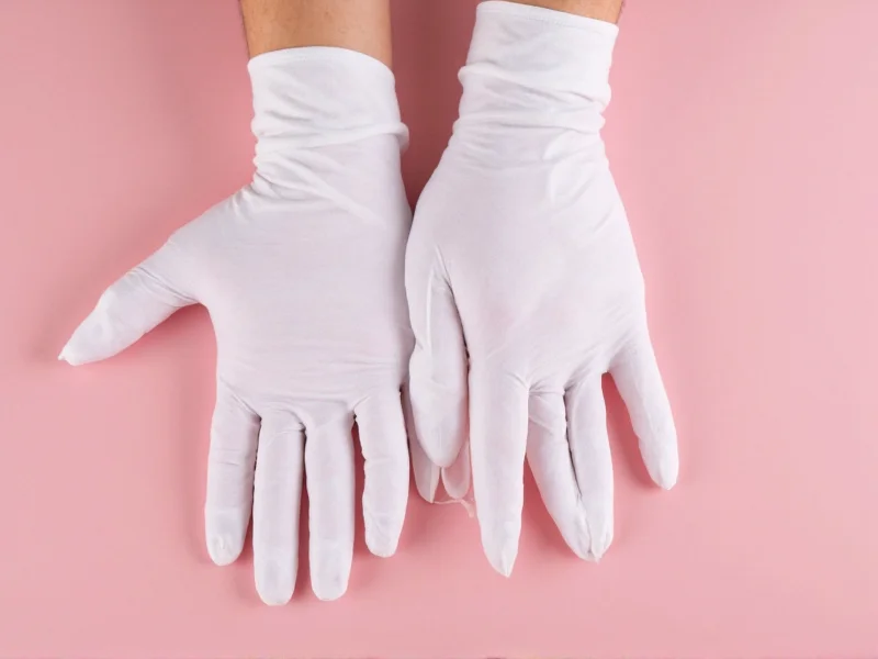 Hands wearing cotton gloves for nail protection